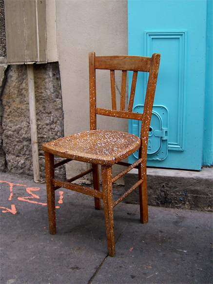 a wooden chair on a city street
