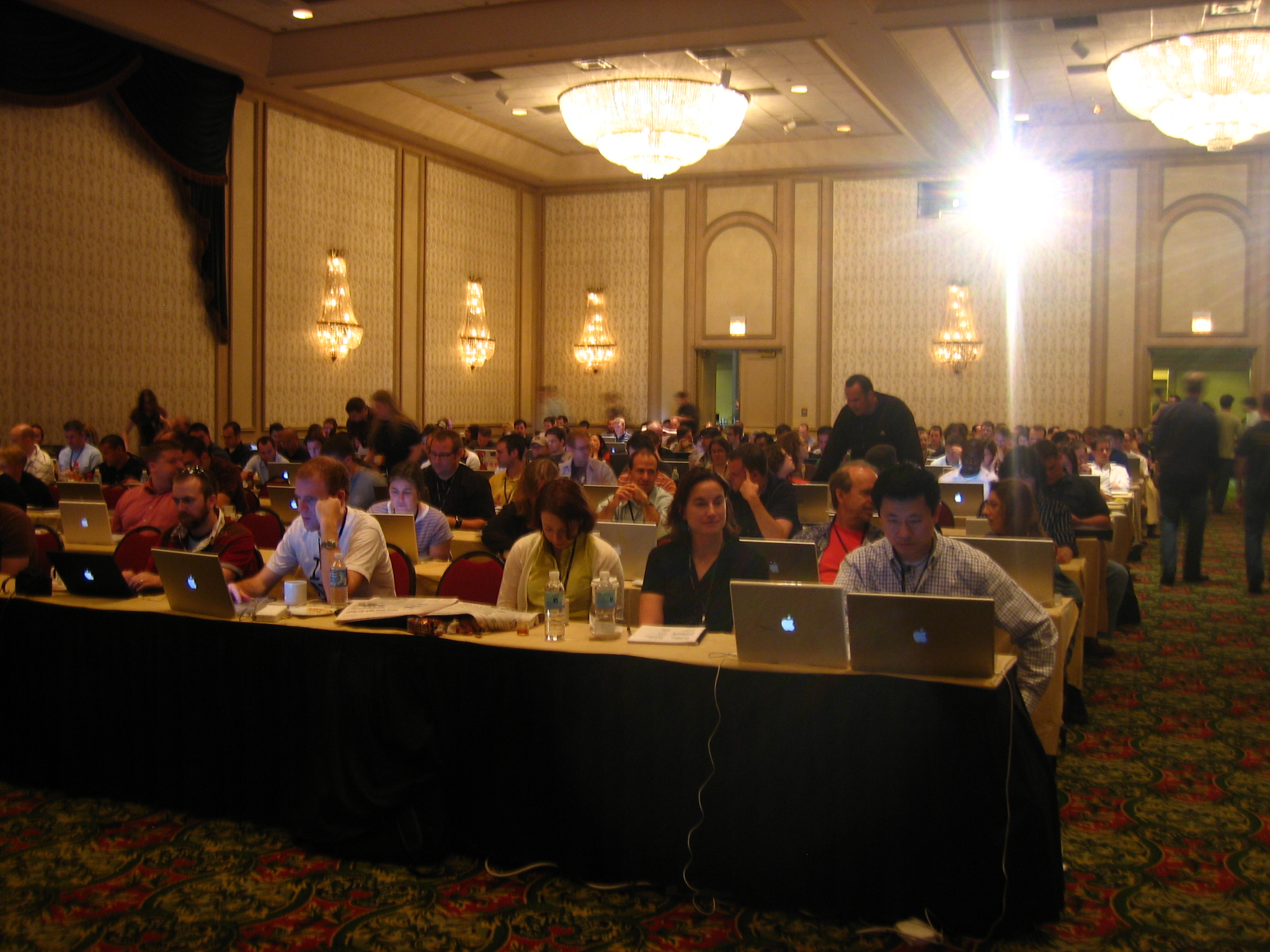 people in a room with several computers on their laps