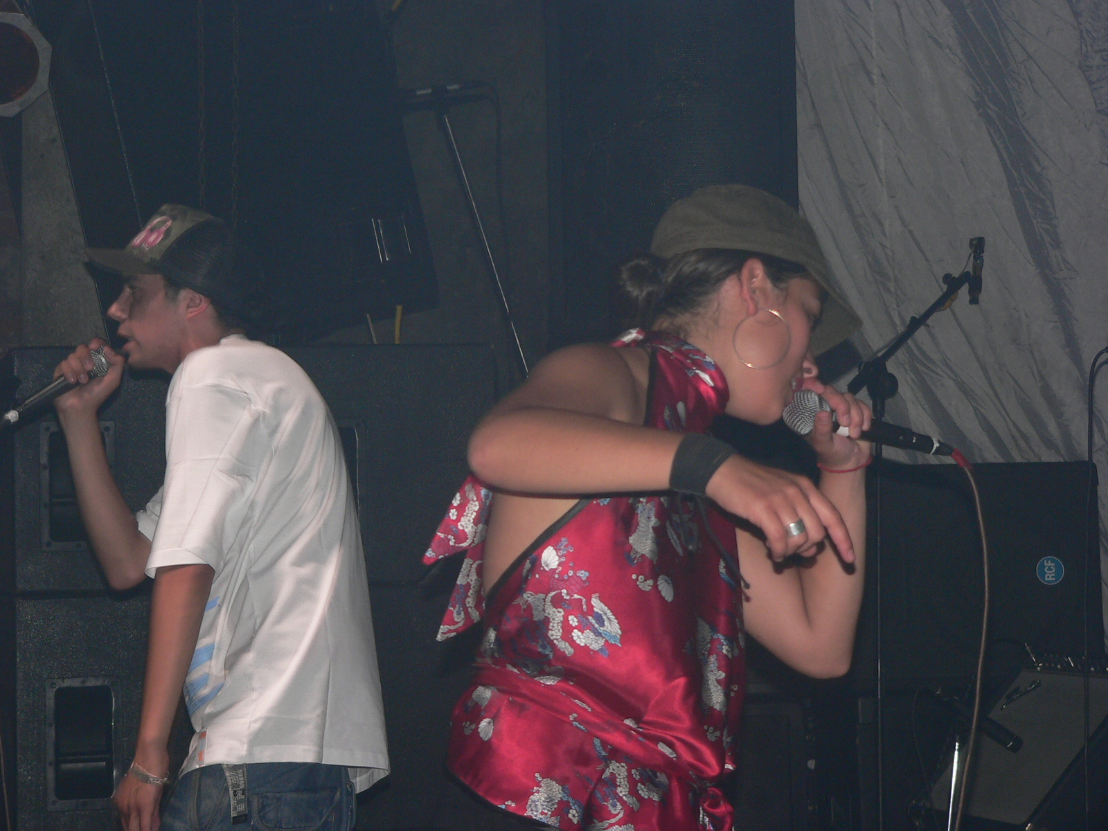 two young men in white shirts standing near a microphone