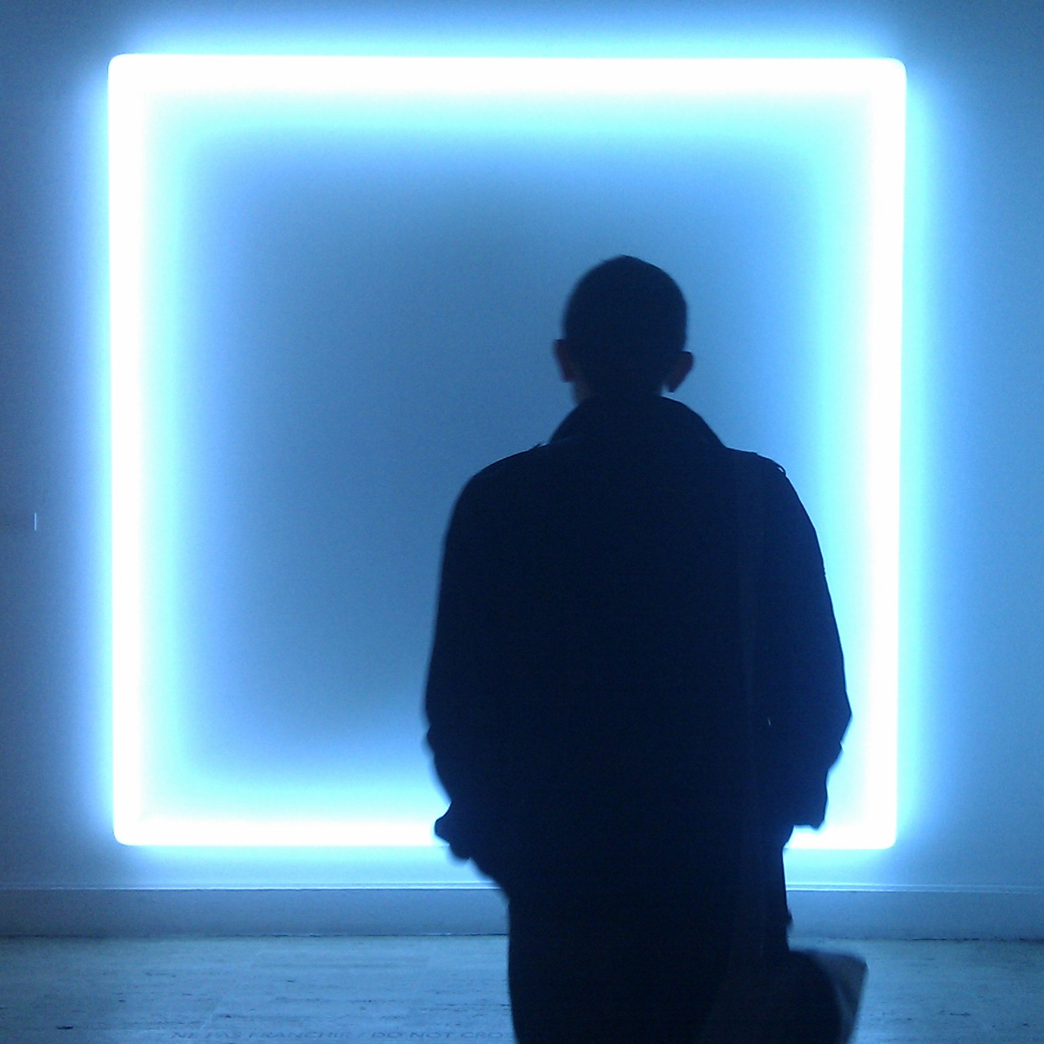 a person is seen walking by an illuminated square