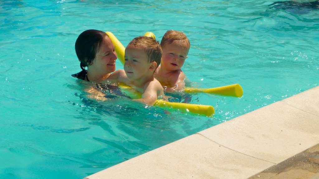 two boys and a girl are playing in a pool
