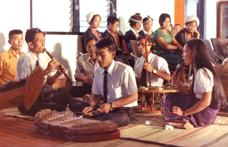 several people sit together and play music instruments