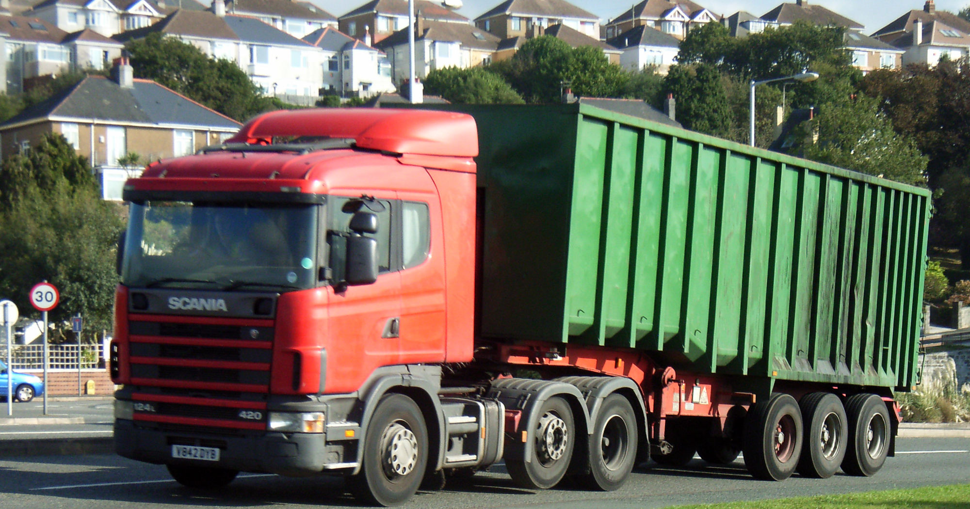 a red and green truck driving down the road