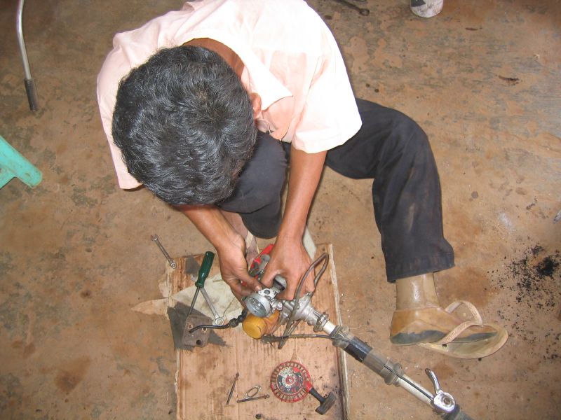 a man kneeling down working with metal tools