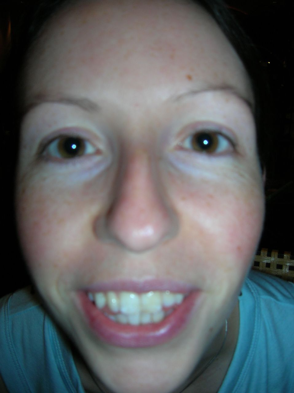woman taking selfie with white teeth in dark room