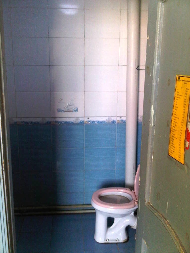 a bathroom with a toilet and a measuring tape