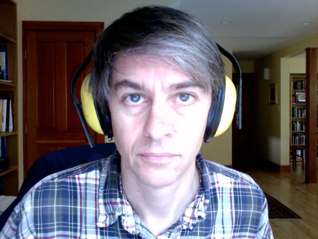 a man with gray hair wearing headphones