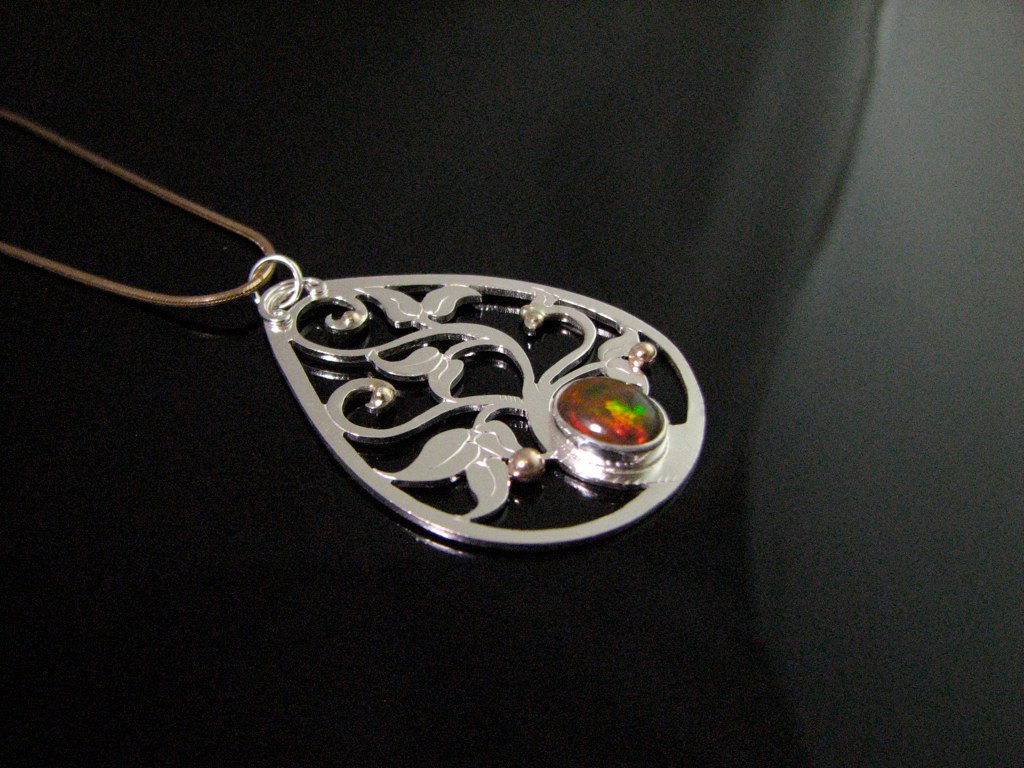 a necklace with two beads and filigree design on it