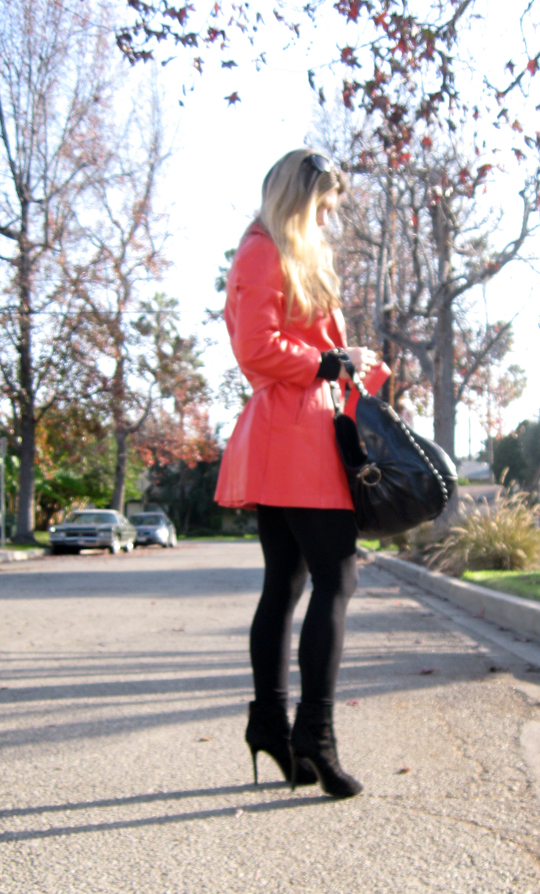 the woman in a red coat is holding her purse