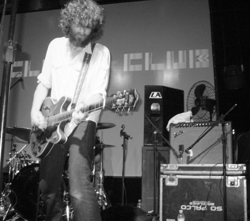 man playing guitar on stage with other equipment