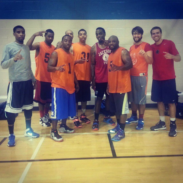 a group of guys in orange and blue shirts on a court