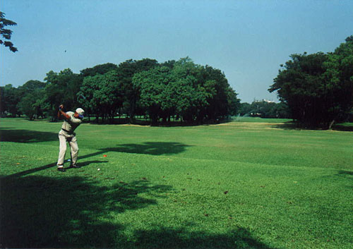 an older person swinging a club while wearing an outfit