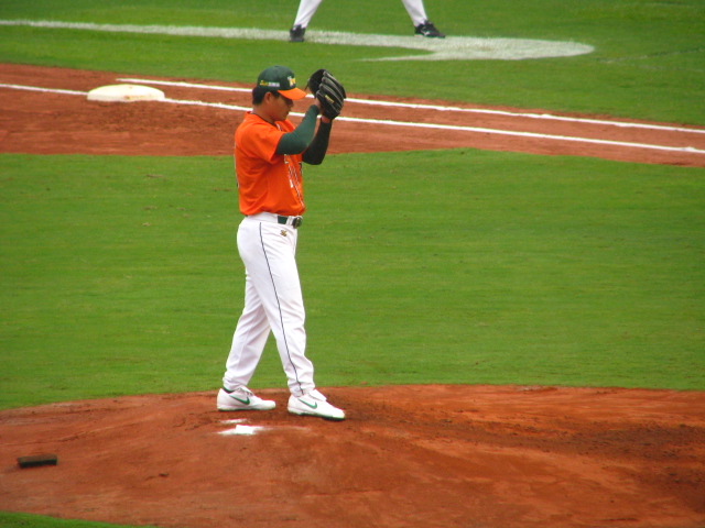 a baseball player wearing an orange shirt on the field