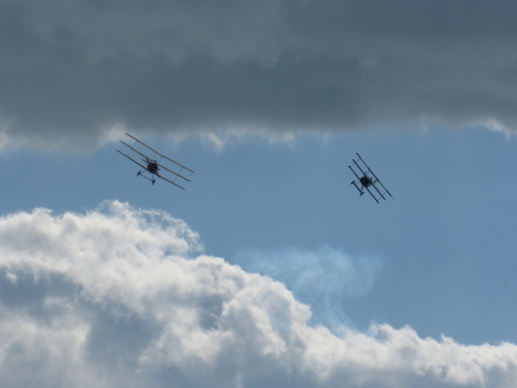 two planes flying overhead during a cloudy day