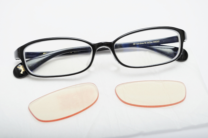 pair of glasses lying on table with clear eye protection cloth