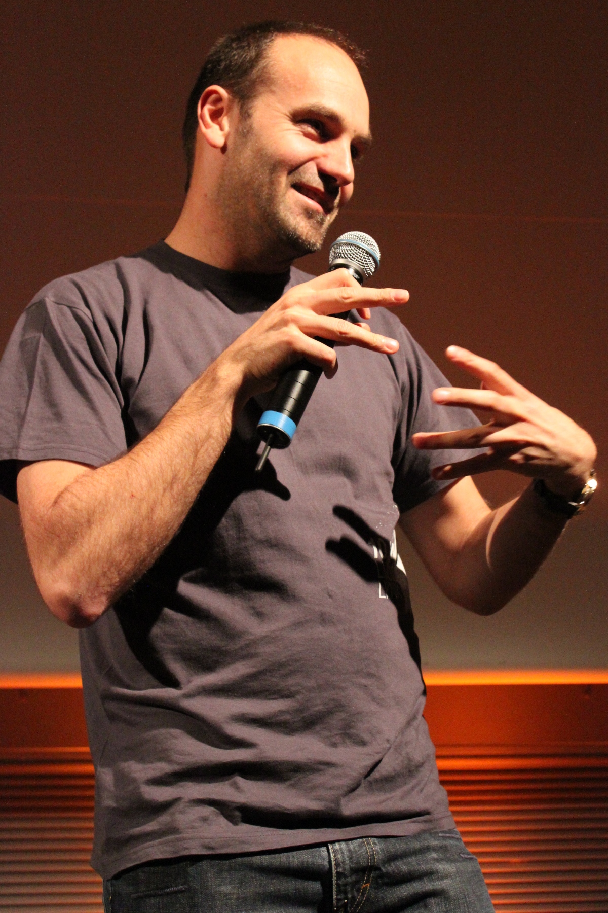 a man holding a microphone up with one hand