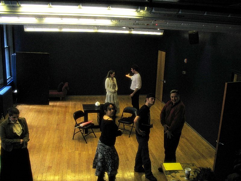 people standing in an empty theatre or dance studio