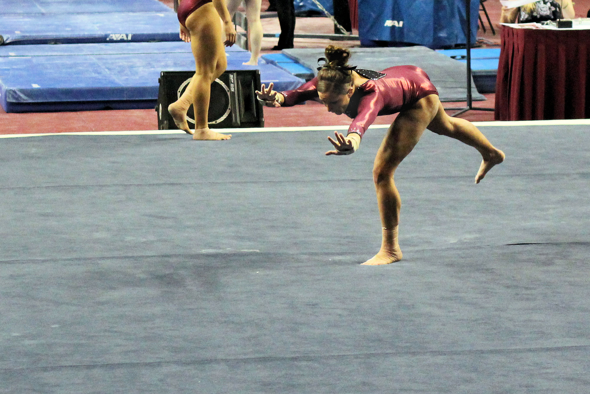 there is a woman on the gymnastics floor doing a stunt