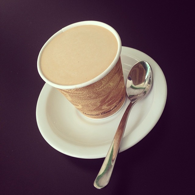 a cup of coffee sitting on top of a saucer and a spoon