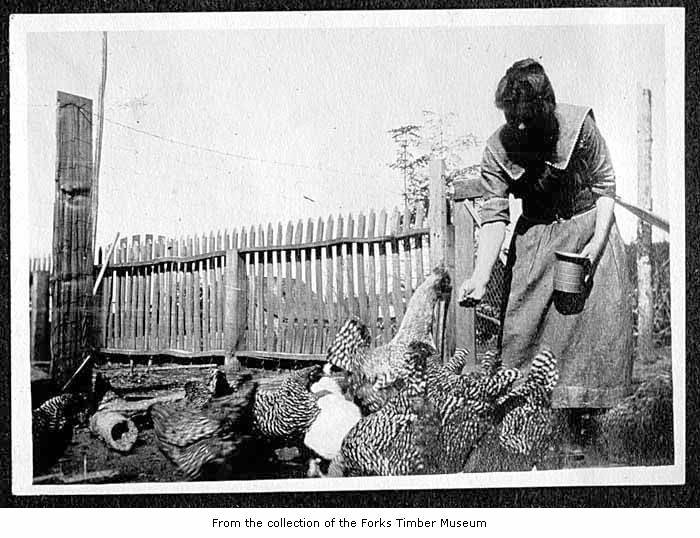 an old po shows a woman feeding chickens