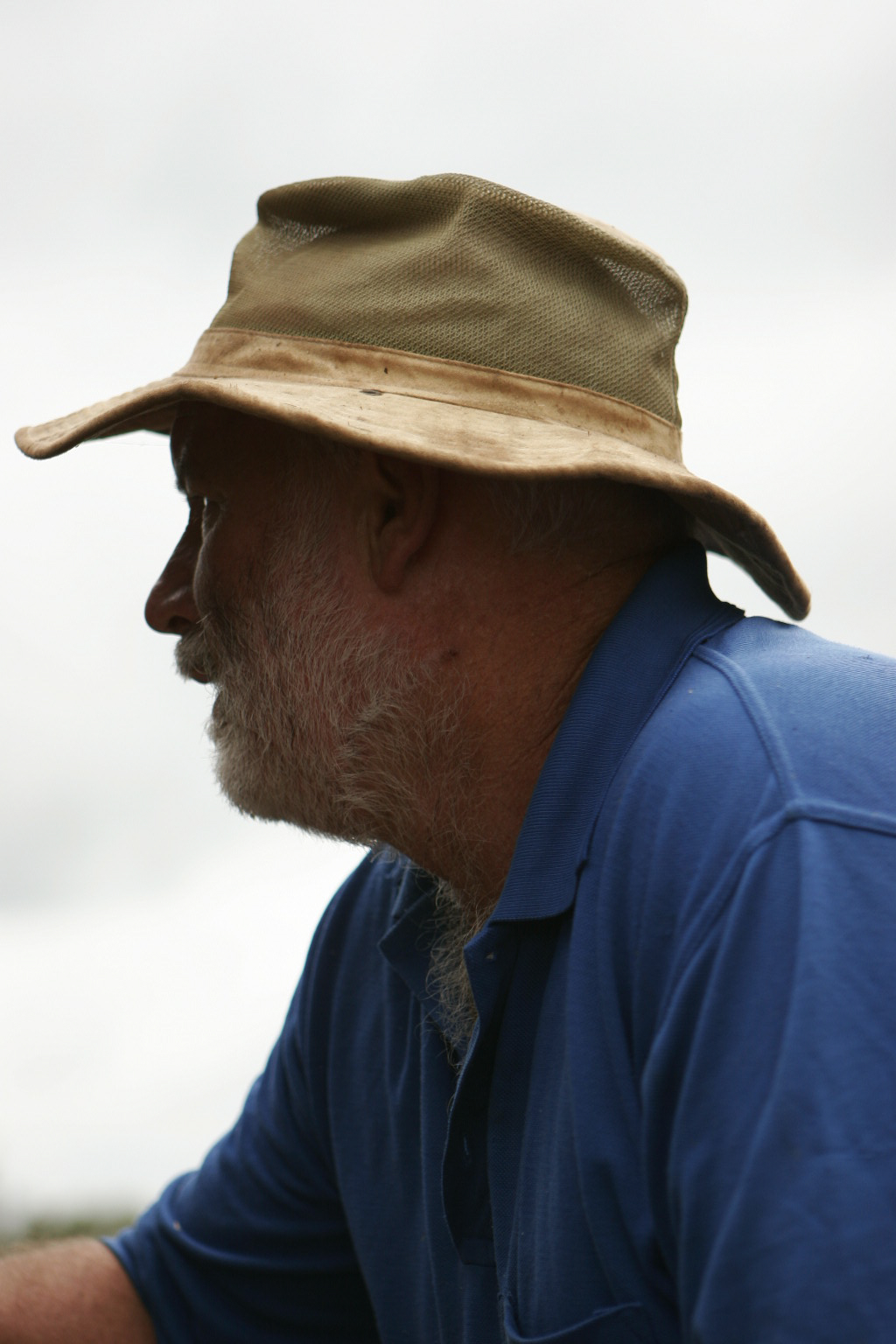 a man with a hat on, staring off to the side