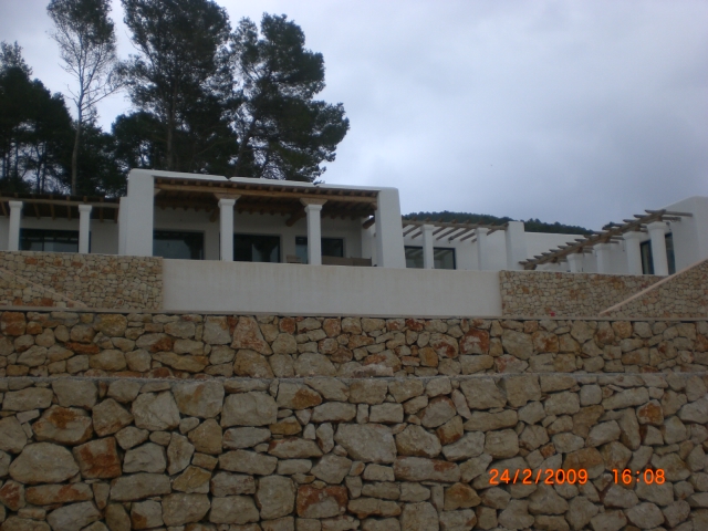 the stone walls of the building are covered in grey rocks