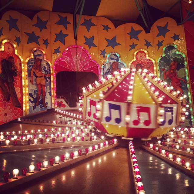 several lighted rides are in rows of candles
