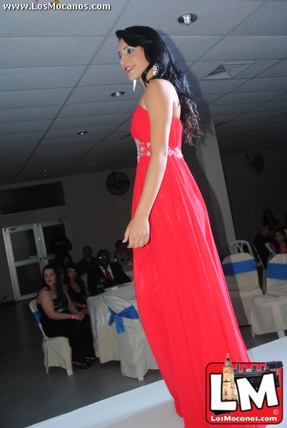 a beautiful woman in a red dress stands on a runway