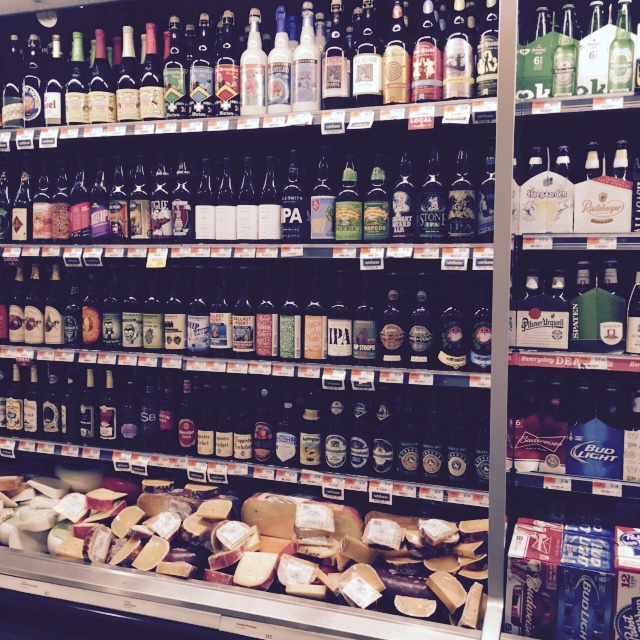 several shelves filled with alcohol and bread