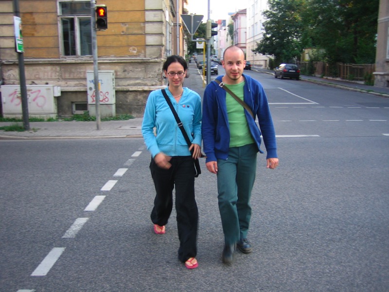 a man and woman are standing in the middle of the street