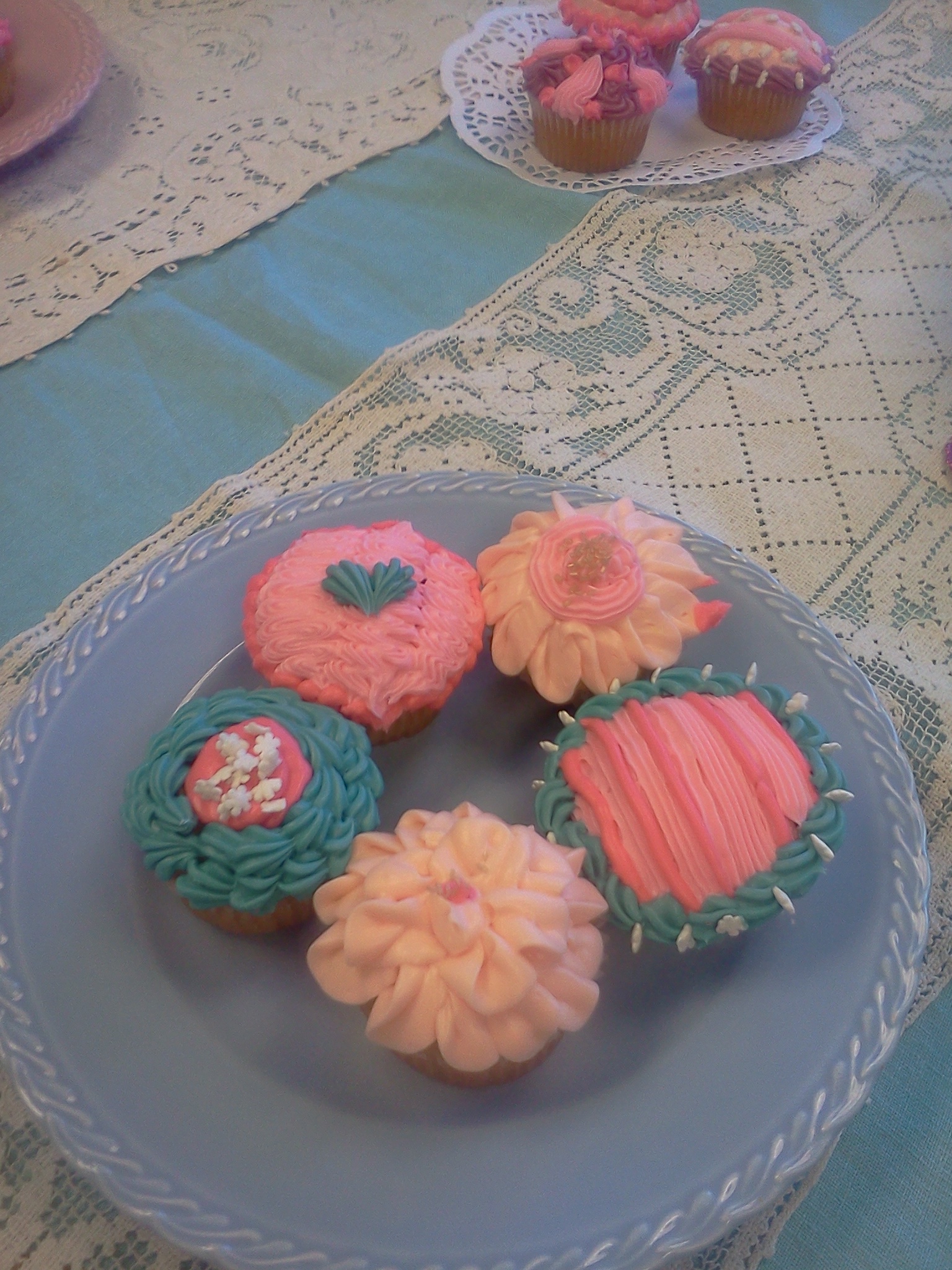 a plate topped with cupcakes sitting on top of a table