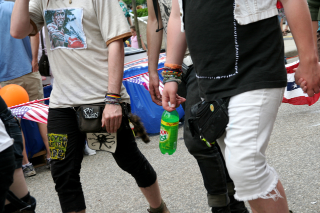 a man with his hands in the pocket while a person puts on a pair of knee pads