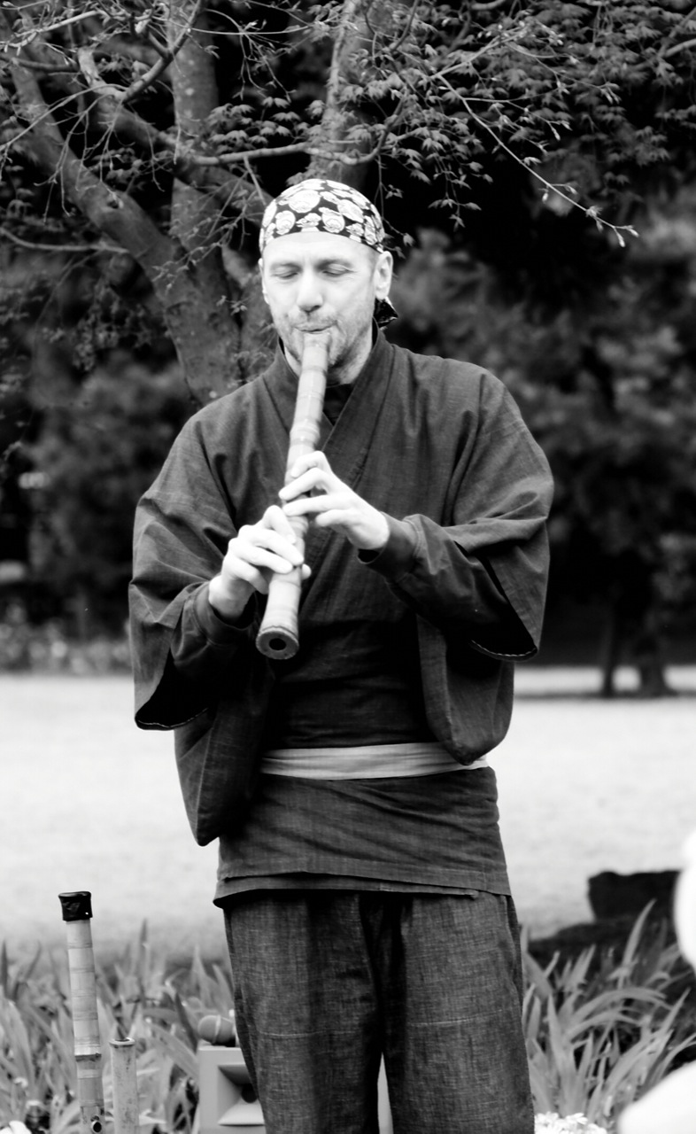 a person holding an oriental instrument in their hands