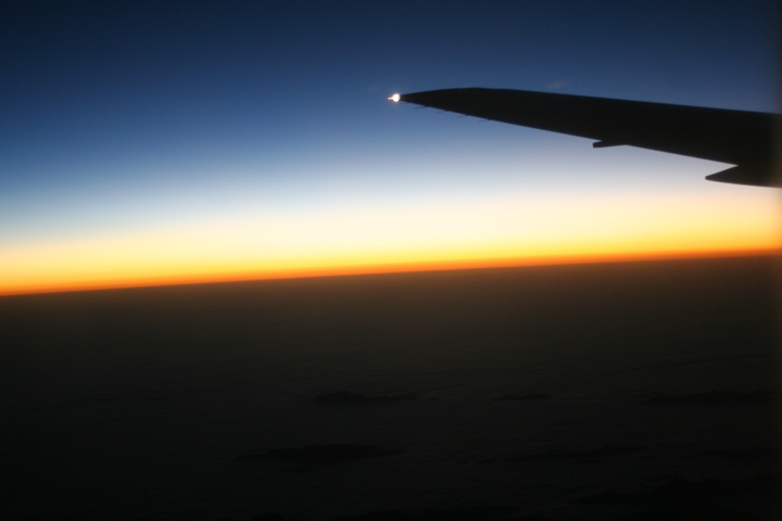 the view from inside an airplane, looking at the sunset