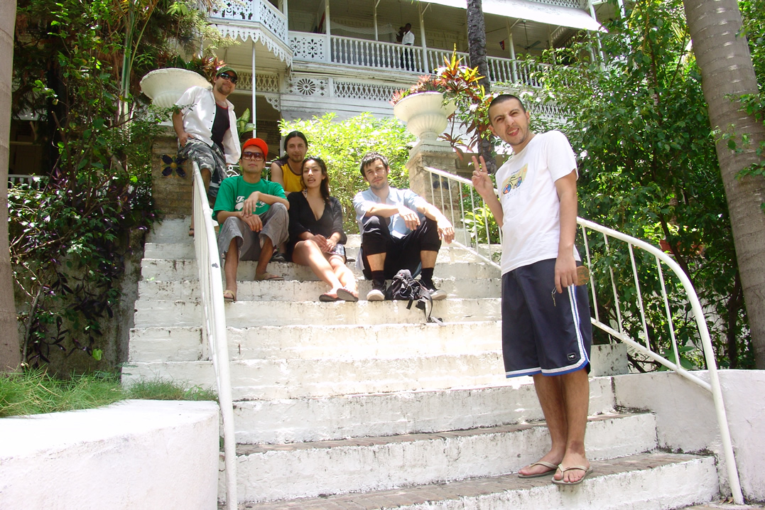 young people sitting on stairs in front of a house