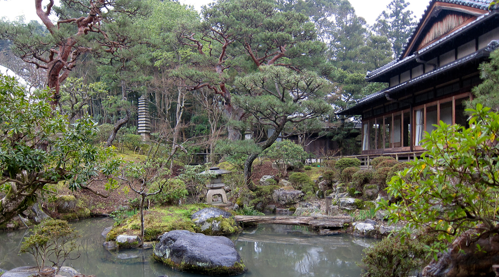 a pond that has rocks and trees surrounding it