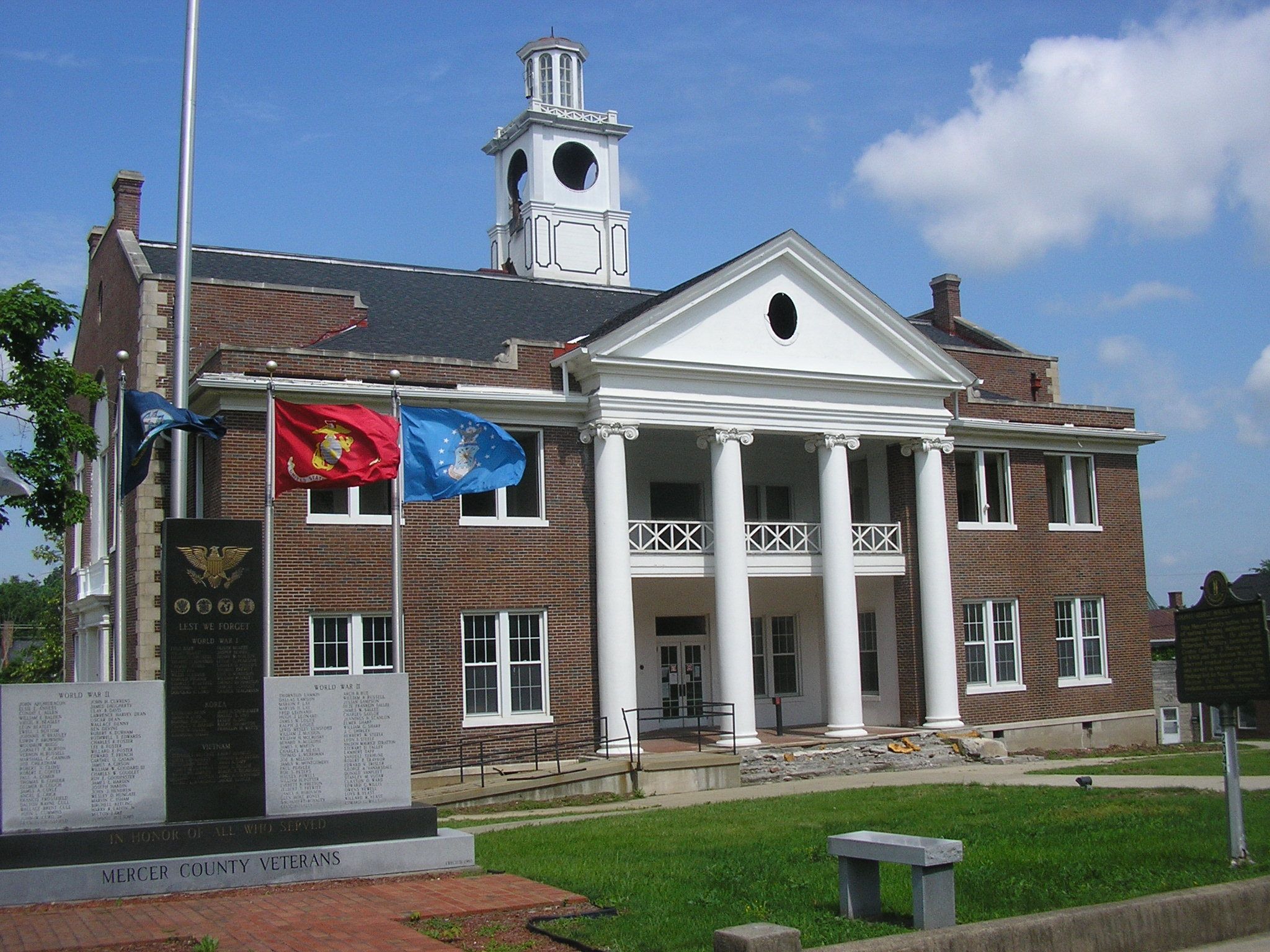 the old courthouse with a small monument and clock tower is a stately home