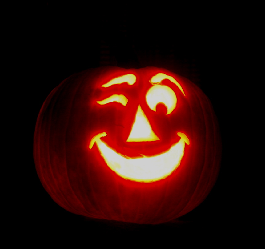 a carved pumpkin with scary eyes is lit
