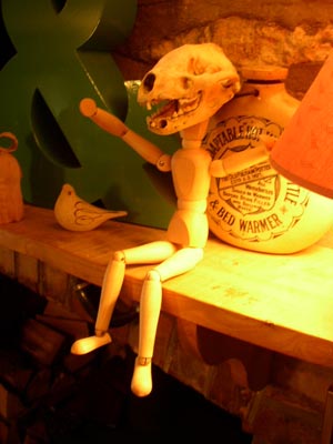 a human figure on a wooden shelf near a lamp