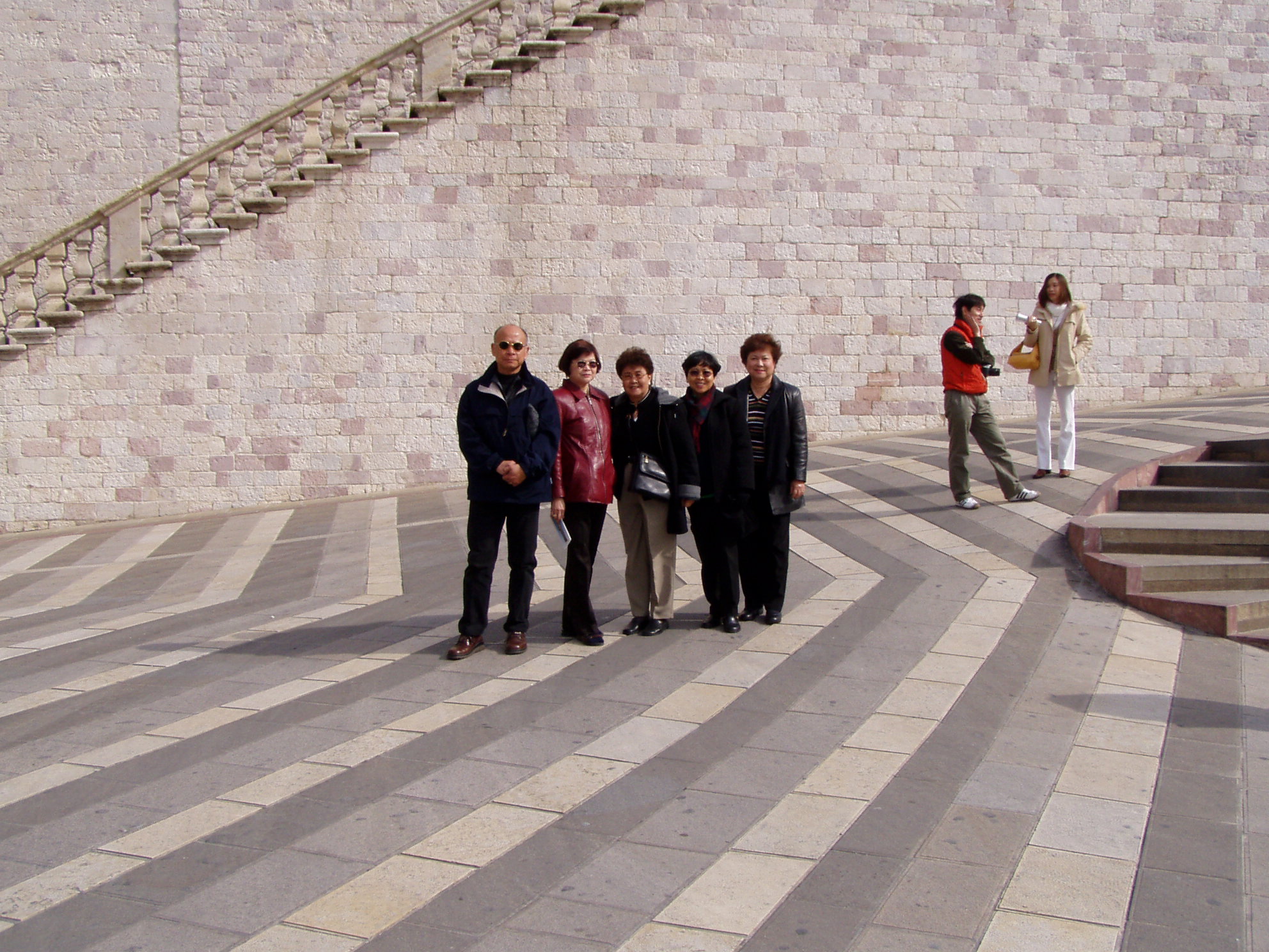 five people are standing in front of a wall