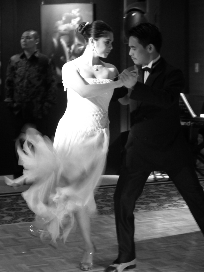 the couple in their wedding outfits dance the twist