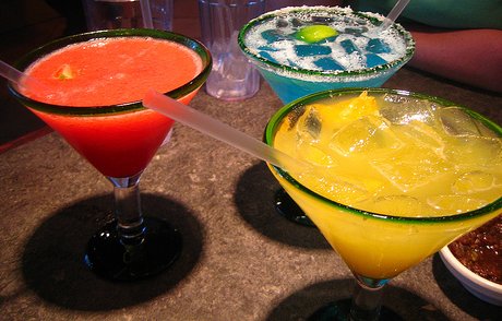 a table topped with three different colored cocktail glasses