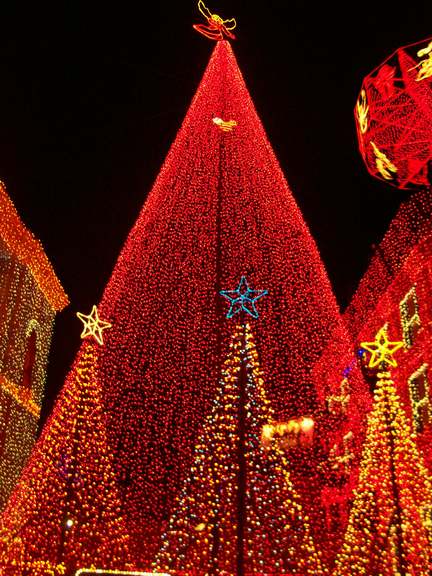 christmas decorations around a brightly lit tree in the city