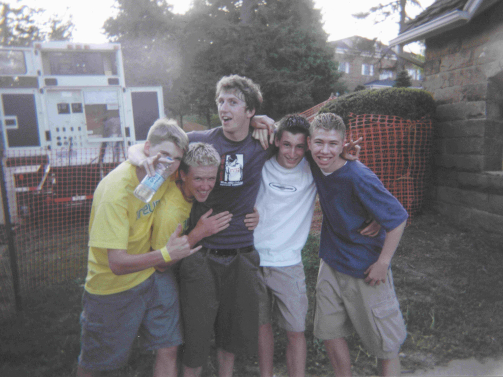 group of s with one holding up their hand in front of a fence