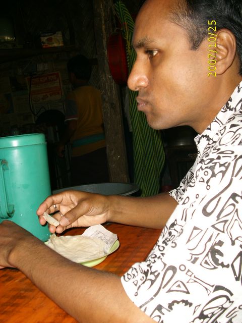 a man at a table putting soing in his hands