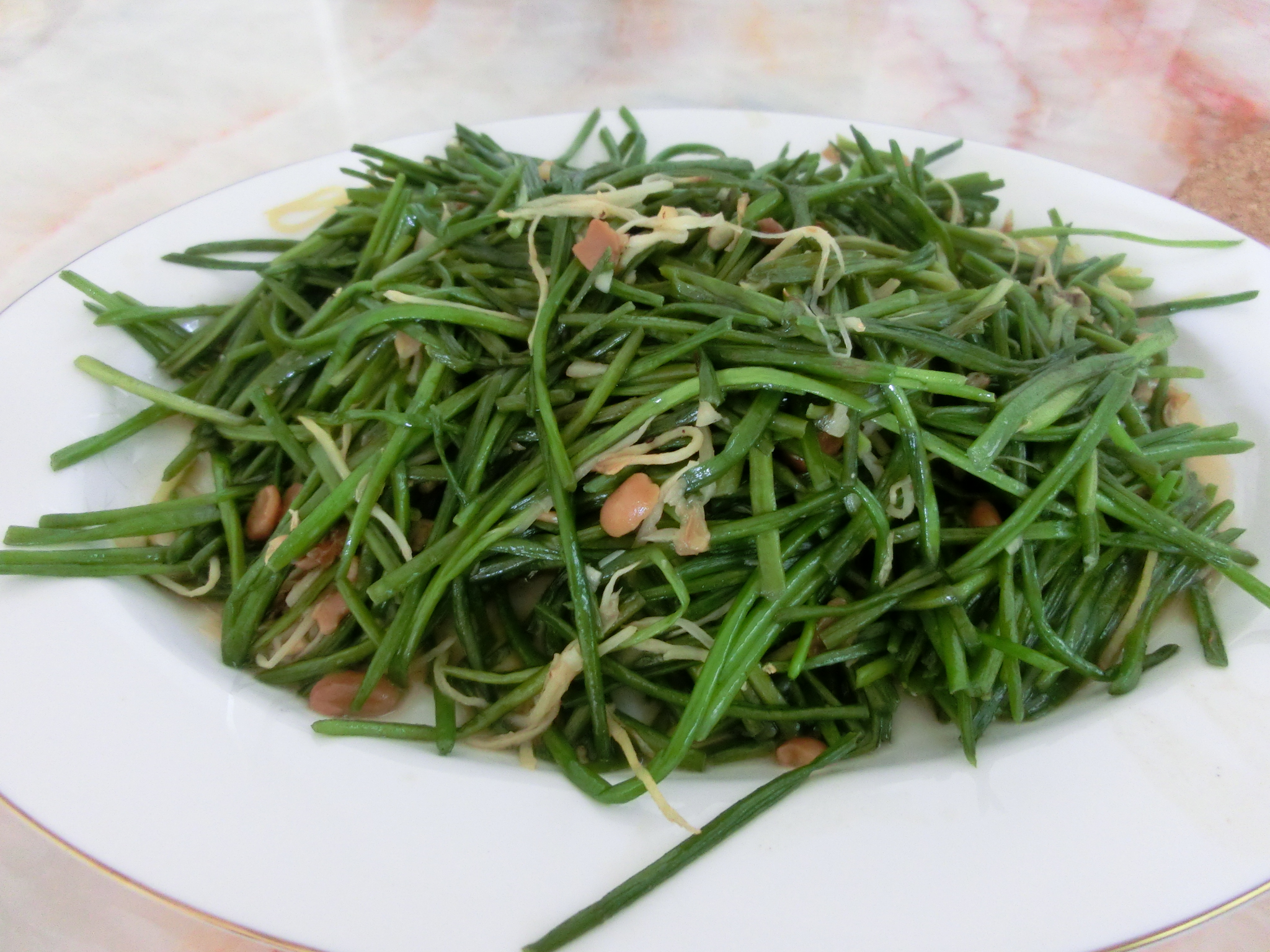 a plate with green beans and carrots with onions