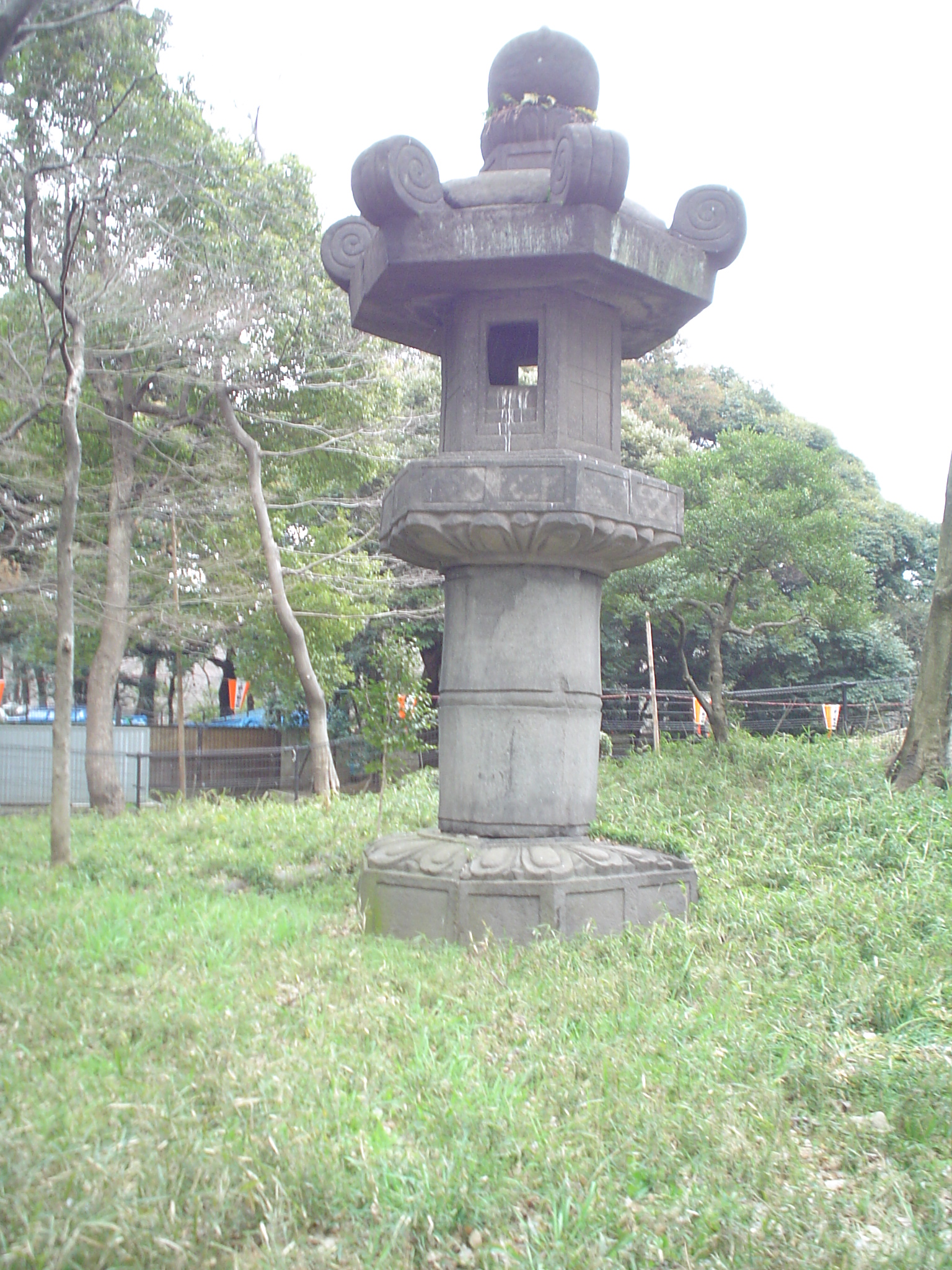 an old style lantern in the middle of some grass