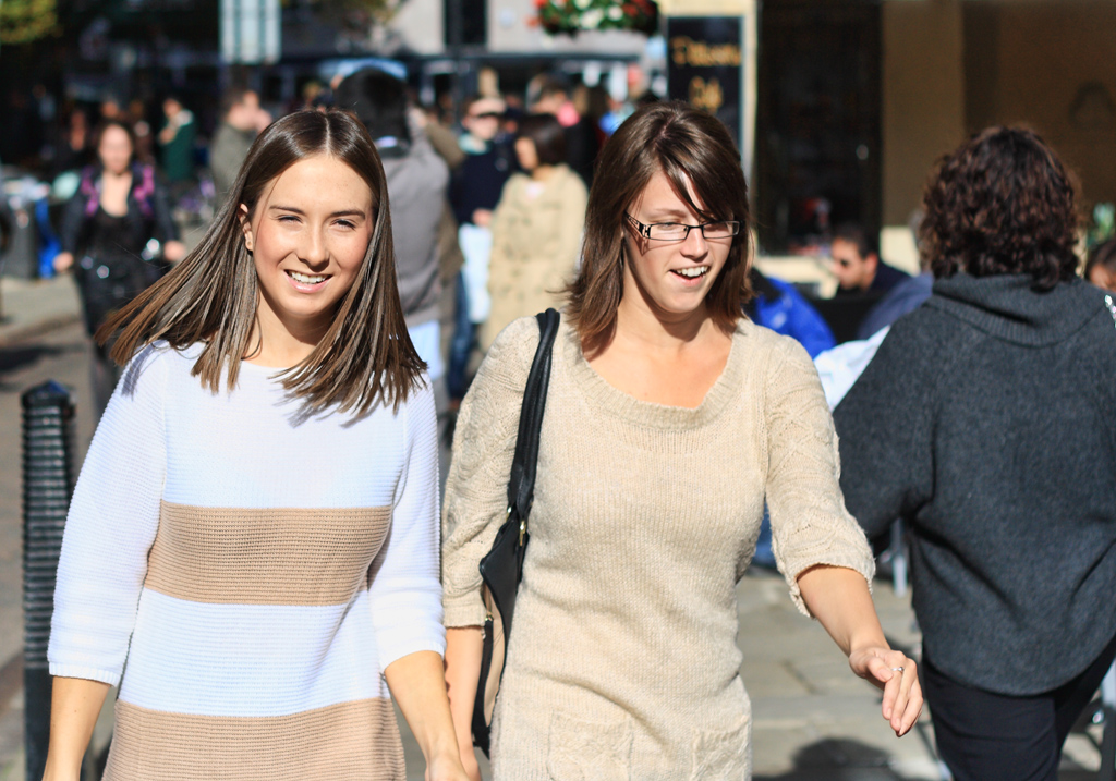 two woman are walking next to each other