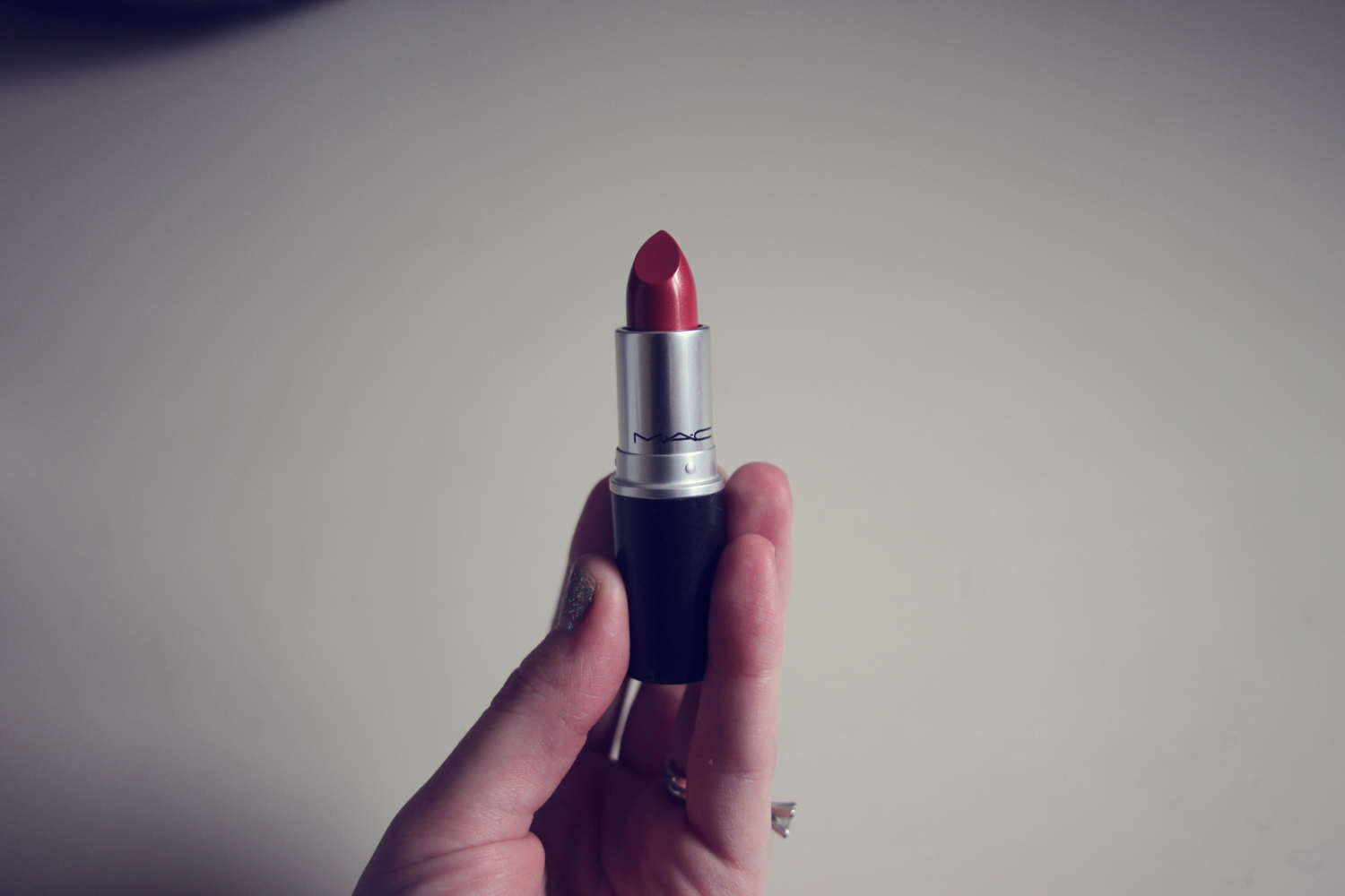 a woman is holding her lipstick with an eyeliner