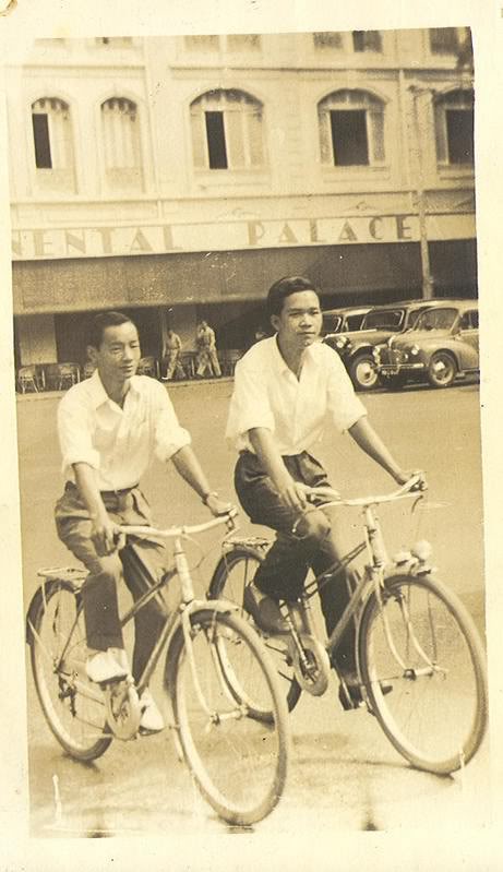 a black and white pograph of two men on bikes